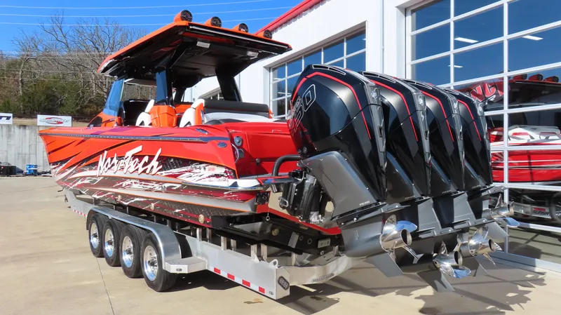 Slide: The Image of 2023 Nor-Tech 450 boat with quad engines on a trailer, vibrant red design. - 2