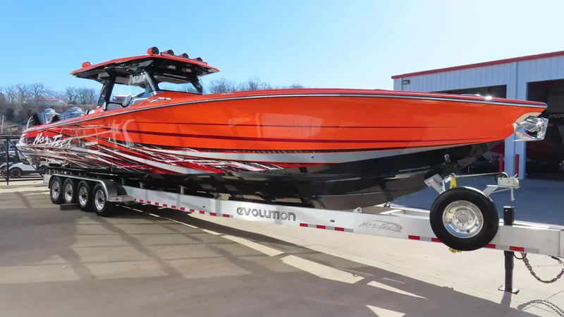 Slide: The Image of 2023 Nor-Tech 450 boat in vibrant orange on a trailer outside a building. - 3