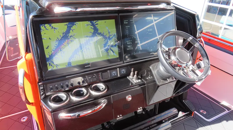 Slide: The Image of 2023 Nor-Tech 450 boat dashboard with navigation screens and steering wheel. - 36