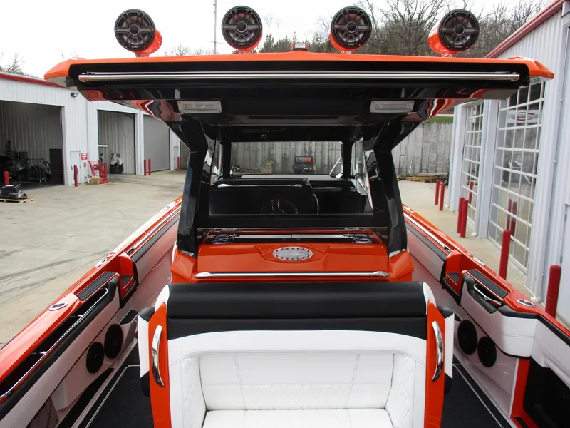 Slide: The Image of 2023 Nor-Tech 450 boat interior with orange and white seating, docked at a marina. - 37