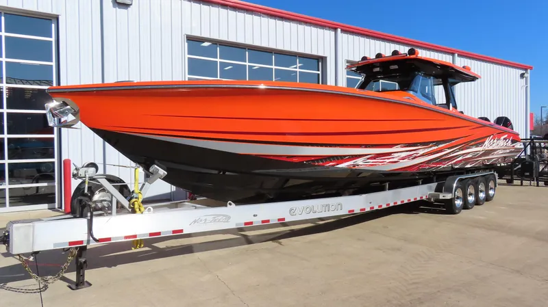 Slide: The Image of 2023 Nor-Tech 450 boat in vibrant orange on a trailer, parked outside a building. - 4
