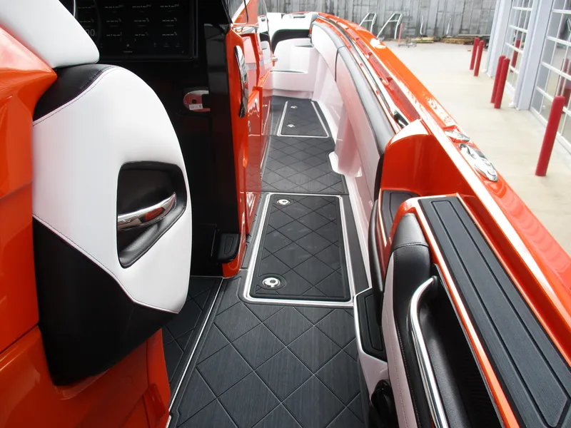 Slide: The Image of 2023 Nor-Tech 450 boat interior with sleek orange and black design, featuring modern seating and flooring. - 52