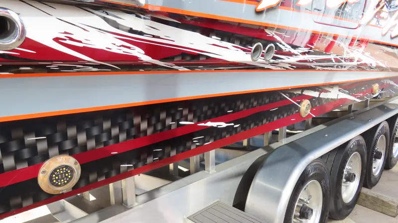 Slide: The Image of 2023 Nor-Tech 450 boat with vibrant graphics and sleek design on a multi-axle trailer. - 9