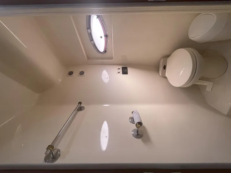 Slide: The Image of Bathroom interior of 1999 Carver 530 Voyager Pilothouse yacht, featuring toilet and porthole. - 26