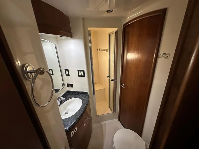Slide: The Image of 1999 Carver 530 Voyager Pilothouse bathroom with sink, shower, and wooden cabinetry. - 32