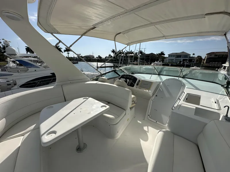 Slide: The Image of 1999 Carver 530 Voyager Pilothouse yacht interior with seating and helm, docked in a marina. - 35