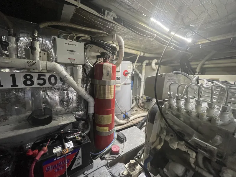 Slide: The Image of Engine room of 1999 Carver 530 Voyager Pilothouse with fire extinguisher and mechanical components. - 44