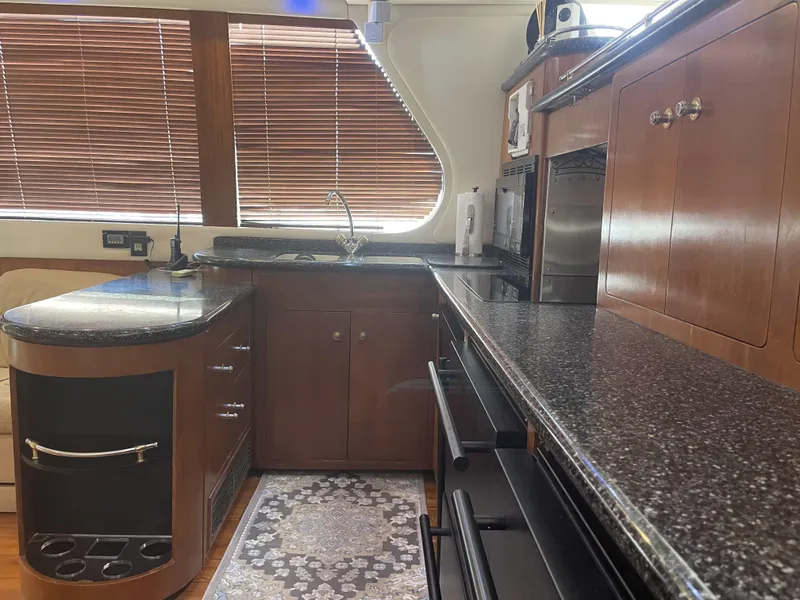Slide: The Image of Luxurious kitchen interior of 1999 Carver 530 Voyager Pilothouse with wood cabinetry and granite countertops. - 14