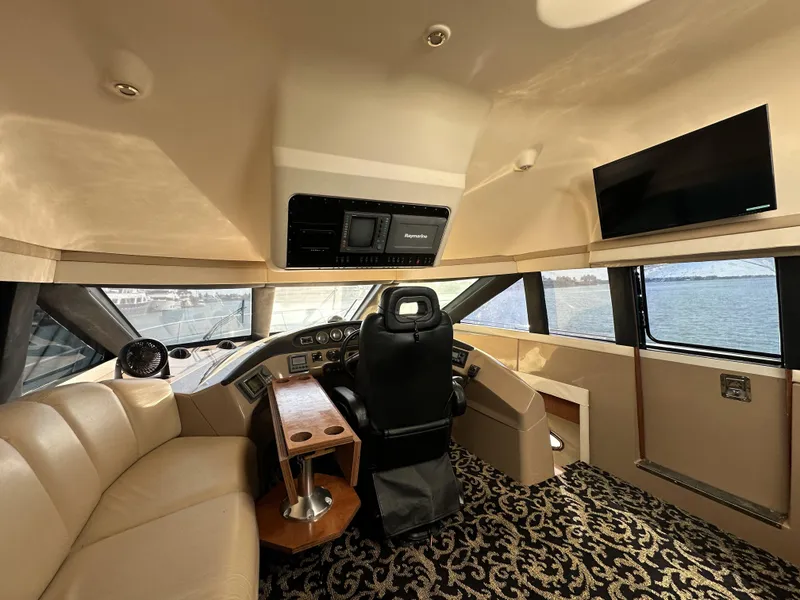 Slide: The Image of Luxurious 1999 Carver 530 Voyager Pilothouse interior with helm, seating, and panoramic windows. - 19