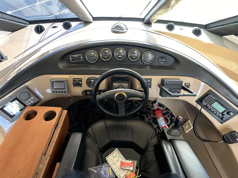 Slide: The Image of 1999 Carver 530 Voyager Pilothouse helm with steering wheel, gauges, and navigation equipment. - 20