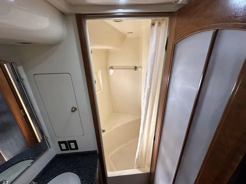 Slide: The Image of 1999 Carver 530 Voyager Pilothouse bathroom with shower, sink, and wooden cabinetry. - 25