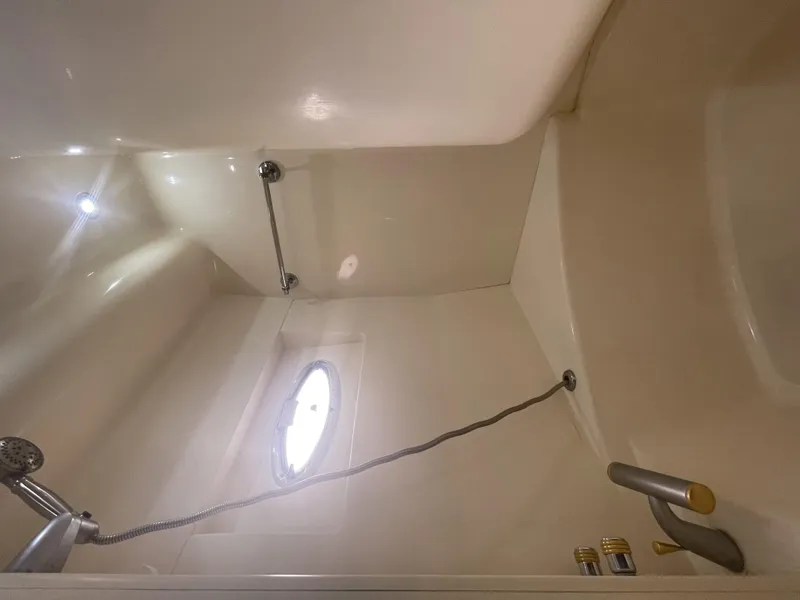 Slide: The Image of Shower area in 1999 Carver 530 Voyager Pilothouse with porthole and handheld showerhead. - 27