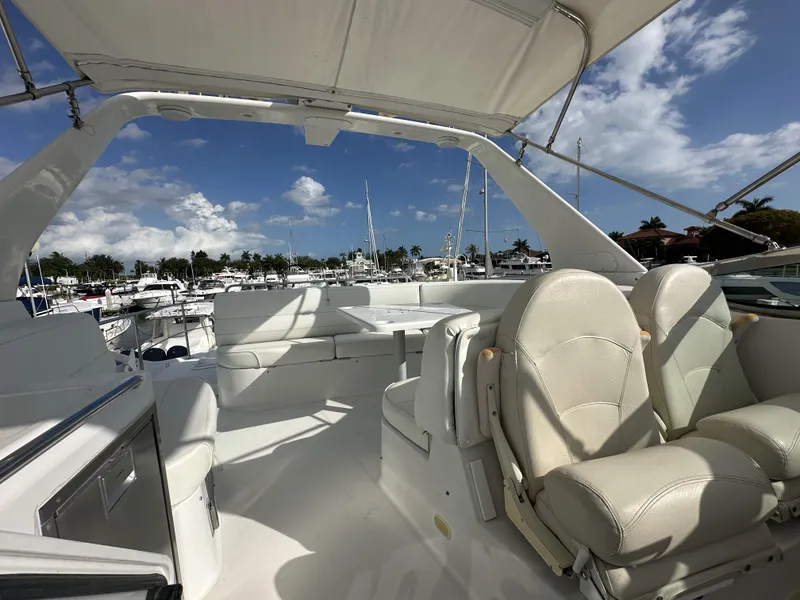 Slide: The Image of 1999 Carver 530 Voyager Pilothouse yacht interior with white seating and marina view. - 37