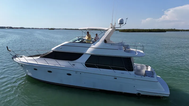 Slide: The Image of 1999 Carver 530 Voyager Pilothouse yacht cruising on calm waters under a clear sky. - 6