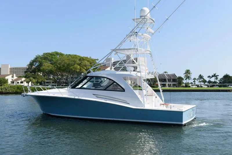 Slide: The Image of 2015 Hatteras 45 Express Sportfish yacht on calm water, showcasing sleek design and fishing tower. - 33