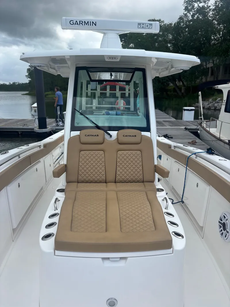 Slide: The Image of 2023 Caymas 341 CC boat with tan seating and Garmin radar, docked by a lake. - 10