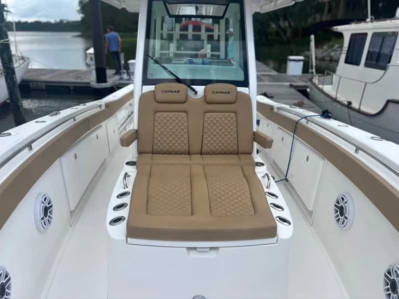 Slide: The Image of 2023 Caymas 341 CC boat with tan seating and sleek design at a dock. - 11