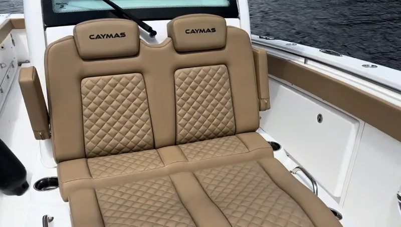 Slide: The Image of 2023 Caymas 341 CC boat with tan quilted seating, on a calm water backdrop. - 13