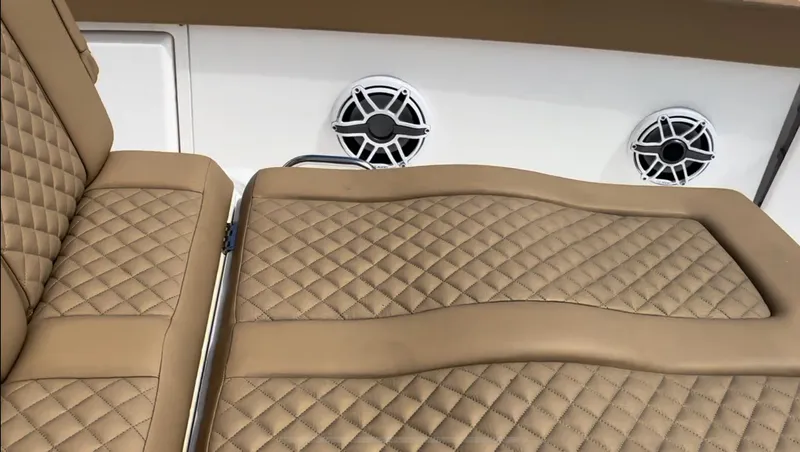 Slide: The Image of Luxurious tan seating on 2023 Caymas 341 CC boat with stylish diamond stitching and speakers. - 15