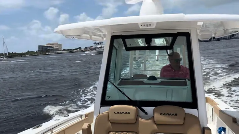 Slide: The Image of 2023 Caymas 341 CC boat cruising on a sunny day with a person at the helm. - 16