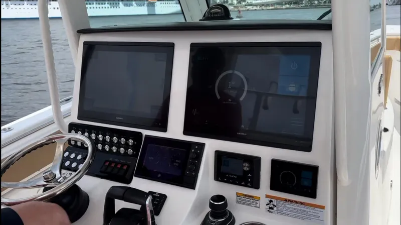 Slide: The Image of 2023 Caymas 341 CC boat dashboard with modern navigation screens and controls. - 20