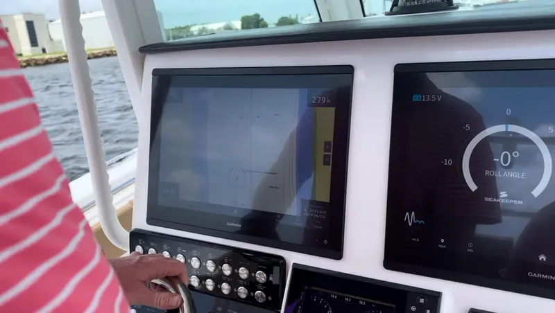 Slide: The Image of 2023 Caymas 341 CC boat dashboard with navigation screens and controls. - 21