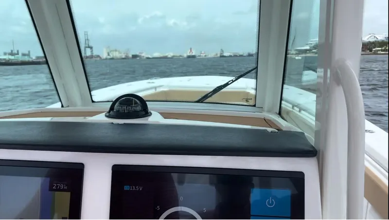 Slide: The Image of 2023 Caymas 341 CC boat dashboard view with water and cityscape in the background. - 22