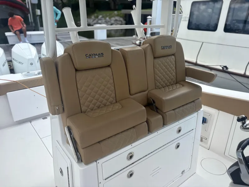 Slide: The Image of 2023 Caymas 341 CC boat with tan cushioned seating and storage compartments. - 28