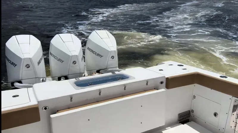 Slide: The Image of 2023 Caymas 341 CC boat with triple Mercury engines on water. - 34