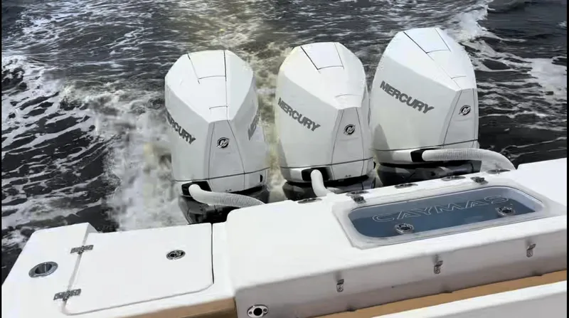 Slide: The Image of 2023 Caymas 341 CC boat with triple Mercury outboard engines on water. - 35