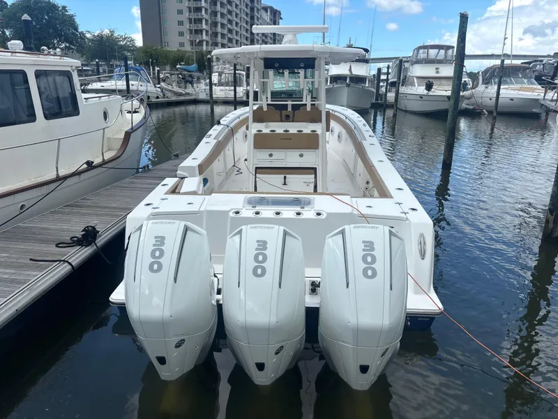 Slide: The Image of 2023 Caymas 341 CC boat with triple 300 horsepower engines docked at a marina. - 4
