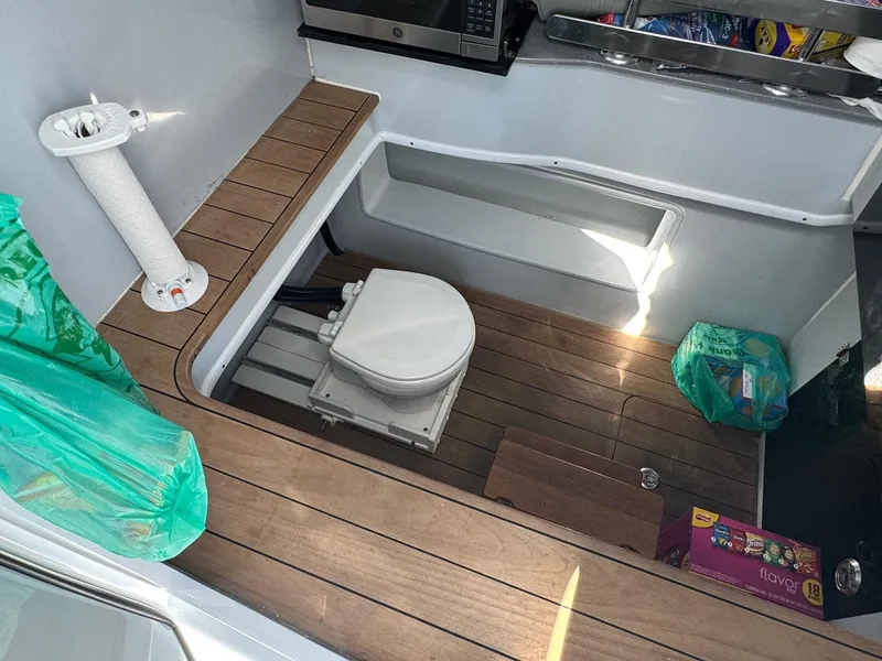 Slide: The Image of 2022 Contender 44 ST boat interior with wooden flooring and compact toilet area. - 11