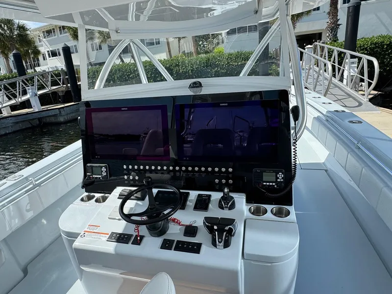 Slide: The Image of 2022 Contender 44 ST boat dashboard with dual screens and control panel. - 13