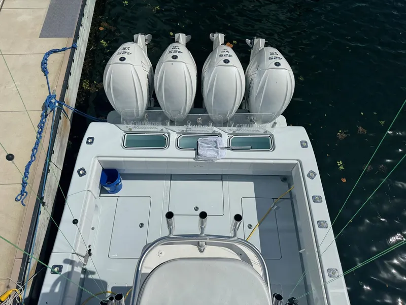 Slide: The Image of 2022 Contender 44 ST boat with four powerful outboard engines docked at marina. - 19