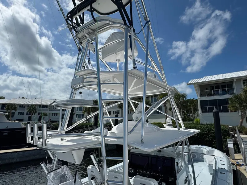 Slide: The Image of 2022 Contender 44 ST boat with tower, docked under a partly cloudy sky. - 20
