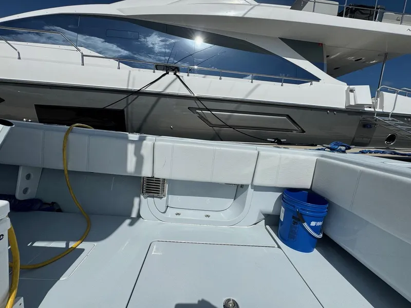 Slide: The Image of 2022 Contender 44 ST boat deck with blue bucket and hose under clear sky. - 23