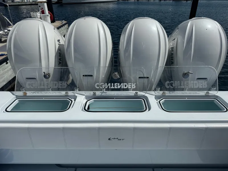 Slide: The Image of 2022 Contender 44 ST boat with four powerful outboard engines docked by the water. - 24