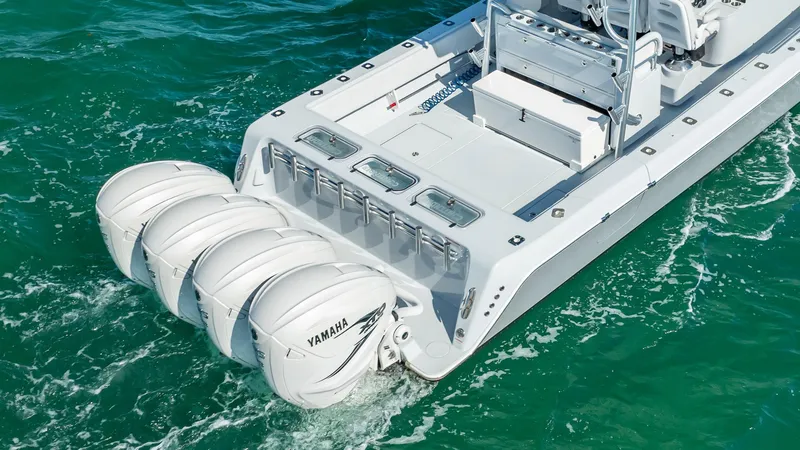 Slide: The Image of 2022 Contender 44 ST boat with four Yamaha outboard engines on turquoise water. - 26