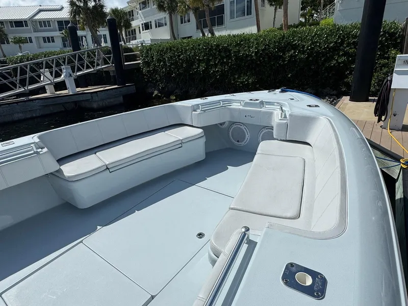 Slide: The Image of 2022 Contender 44 ST boat with spacious seating, docked near waterfront homes. - 8