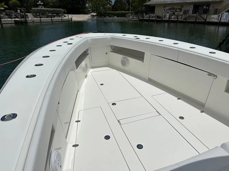 Slide: The Image of 2018 SeaVee 390Z boat deck with spacious seating and storage, docked by a serene waterfront. - 3