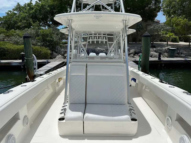 Slide: The Image of 2018 SeaVee 390Z boat with white seating, docked in a serene marina setting. - 5
