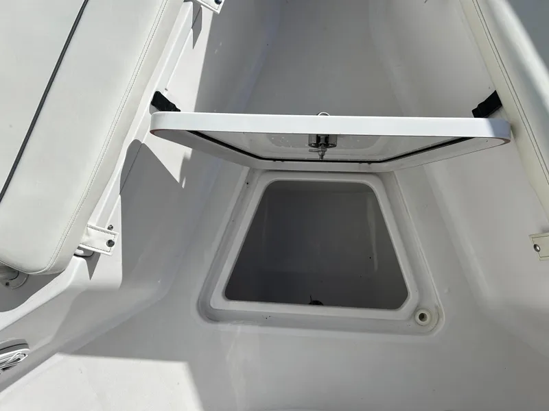 Slide: The Image of 2020 Sportsman Open 232 Center Console boat storage compartment with open hatch. - 26