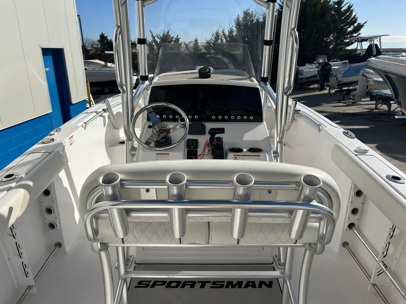 Slide: The Image of 2020 Sportsman Open 232 Center Console boat interior with steering wheel and rod holders. - 9