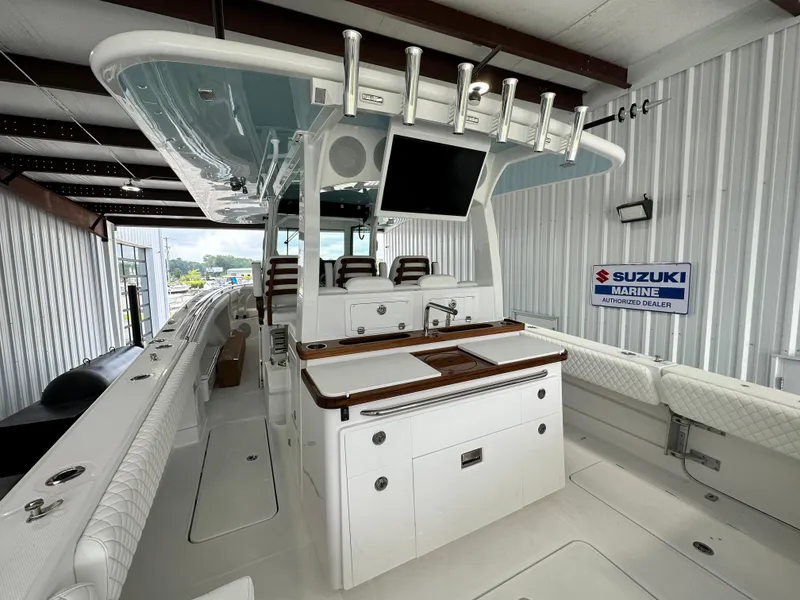 Slide: The Image of 2025 HCB 42 Lujo boat interior with seating and fishing equipment in a storage facility. - 17
