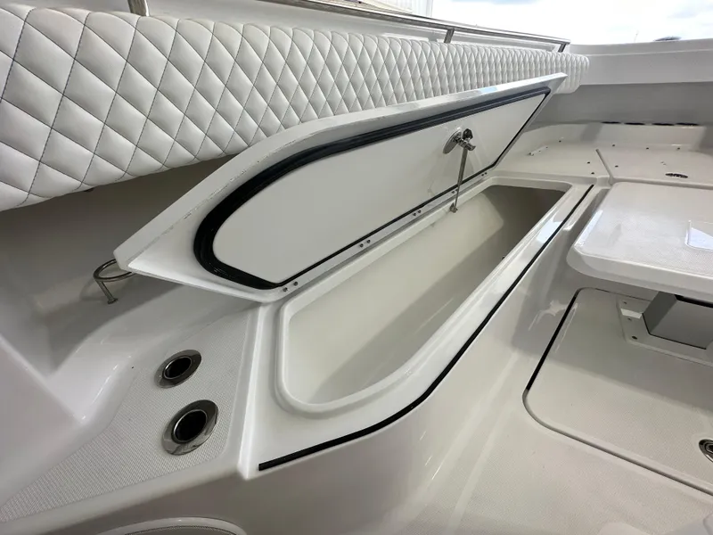 Slide: The Image of HCB 42 Lujo 2025 boat interior with open storage compartment and quilted seating. - 8