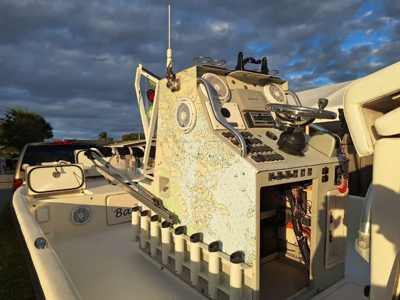 Slide: The Image of Bay Hawk 204 boat console with map design, showcasing controls and storage, under cloudy sky. - 10