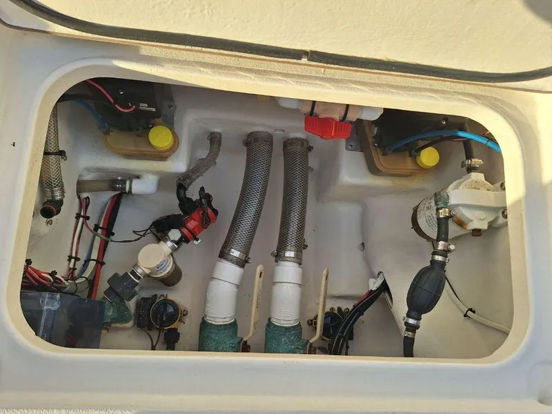 Slide: The Image of 1992 Bay Hawk 204 boat engine compartment with hoses, wiring, and mechanical components. - 14