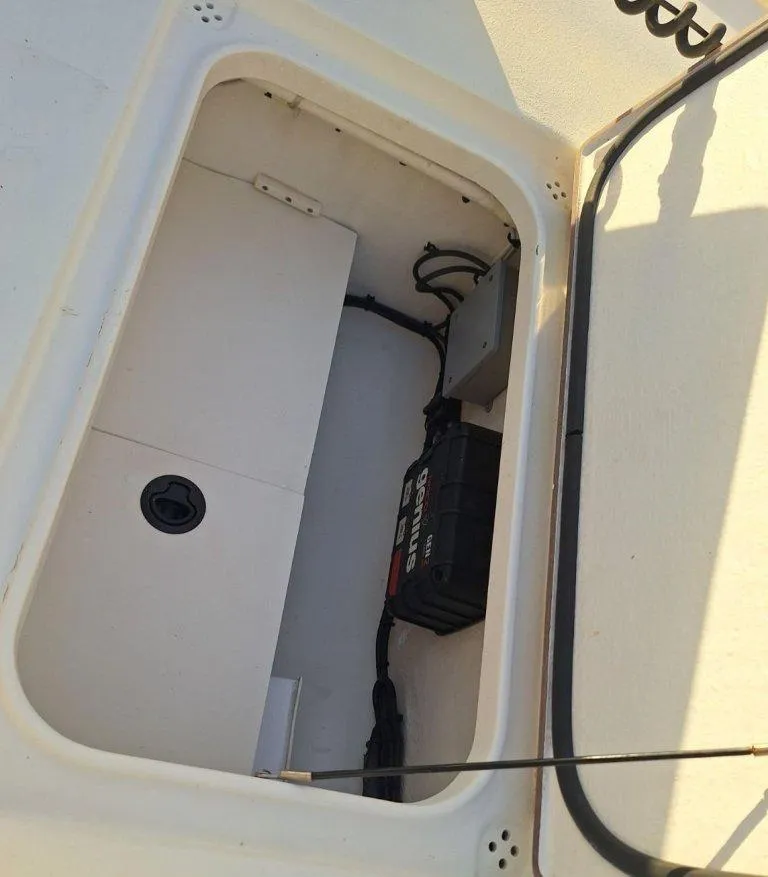Slide: The Image of Storage compartment of a 1992 Bay Hawk 204 boat with battery and wiring. - 16