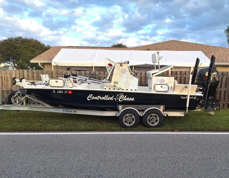 Slide: The Image of Bay Hawk 204 boat on trailer, labeled "Controlled Chaos," parked by a house. - 5