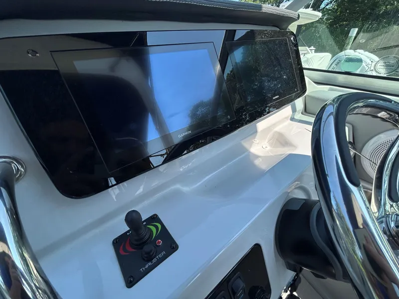 Slide: The Image of 2025 Regal 26 XO boat dashboard with Garmin display and thruster control. - 12